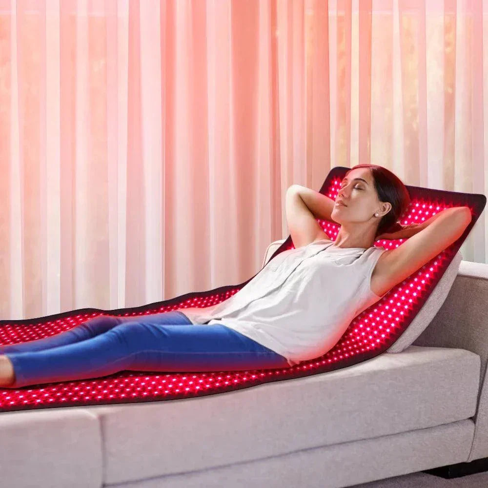 Woman relaxing on a 700w high irradiance red light therapy mat, emitting 660nm and 850nm near infrared light for therapeutic benefits.